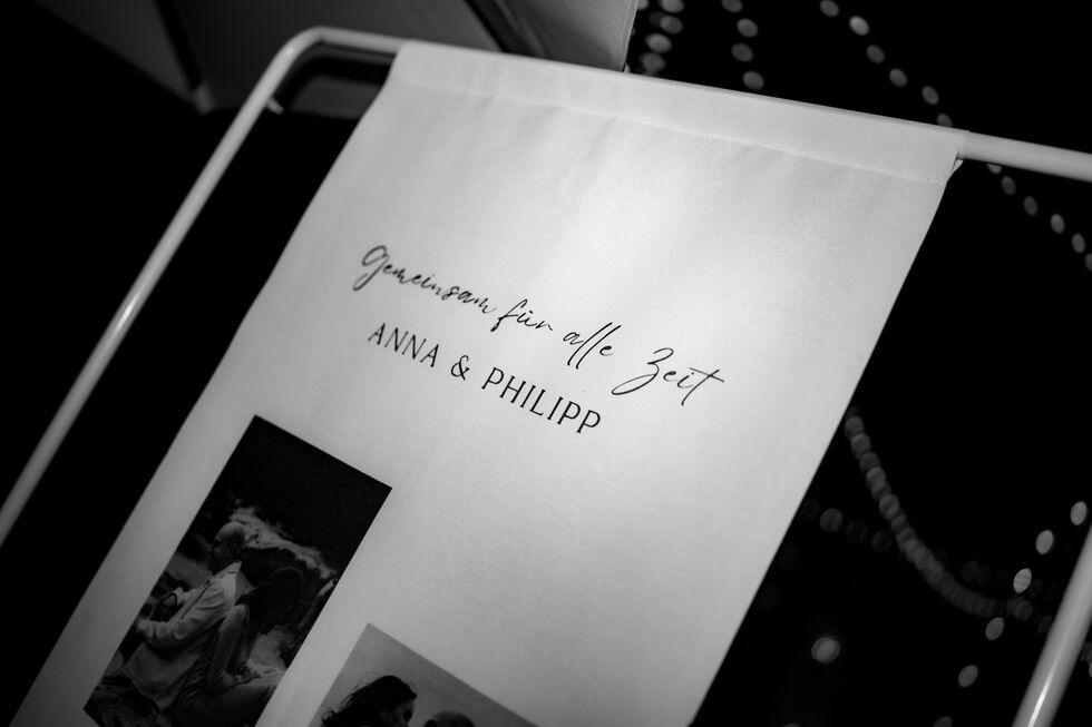 Stoffbanner mit der Aufschrift „Gemeinsam für alle Zeit – Anna & Philipp“ in Nahaufnahme.