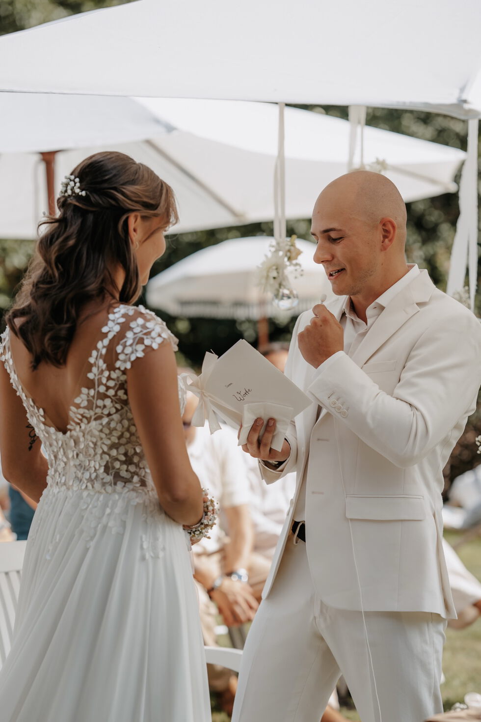 Bräutigam liest sein Eheversprechen vor, während er der Braut gegenübersteht.